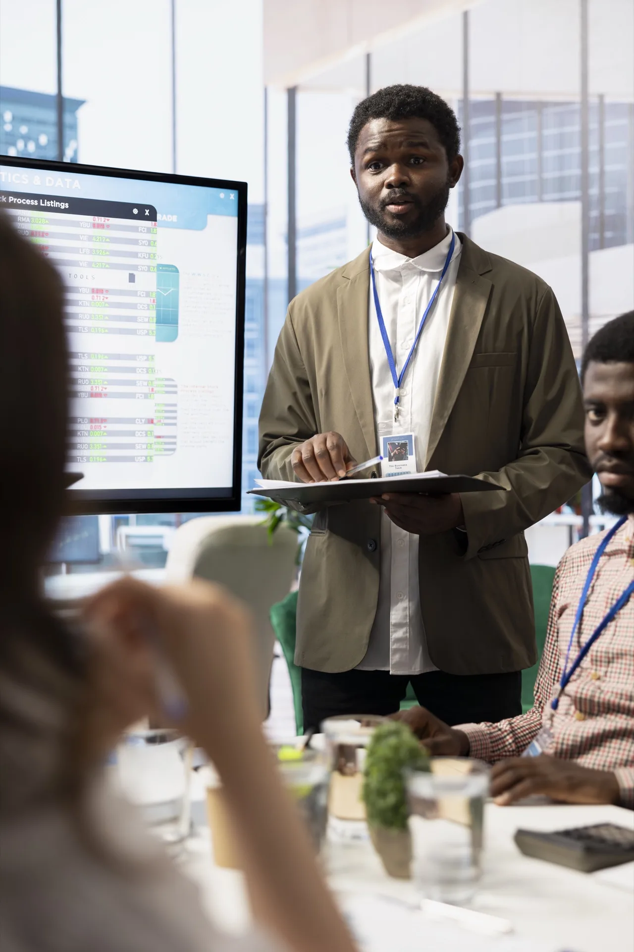 Cadre dirigeant africain présentant des analytics financiers à son équipe de direction lors d'un briefing corporate.